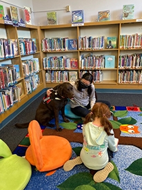 Chuck the read to a therapy dog enjoys listening to children read stories to him