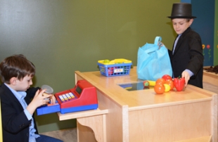 Two boys play with costumes and cash registers
